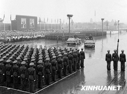 国防部部长彭德怀在阅兵总指挥杨成武陪同下，冒雨检阅中国人民解放军部队（图片来源：新华网）。