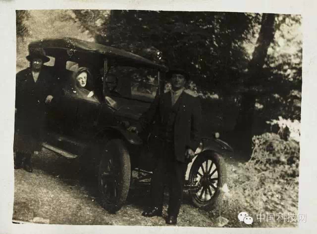 威廉姆的两个朋友依靠在汽车旁,这对夫妻已故儿子的鬼魂出现在车轮上。(威廉·霍普,c.1920. 国家媒体博物馆收藏)