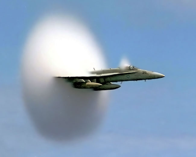 战斗机的飞行速度能够轻松达到超音速，图中可以看到明显的冲击波