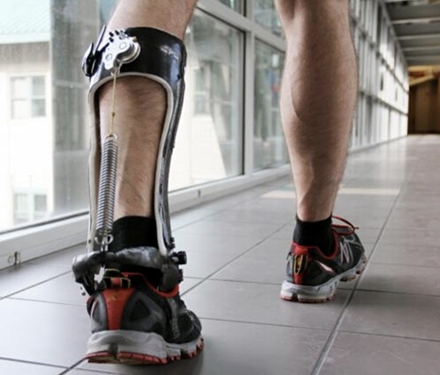 一条腿装着“外骨骼”的学生走在校园里。当脚着地时，无动力的离合器（图中左上方）与一根和跟腱相平行的弹簧（左边）相啮合，减轻了小腿肌的负担，让行走更省力。图片来源：Carnegie Mellon University College of Engineering